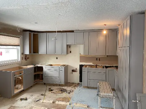 Kitchen renovation with gray cabinets and unfinished layout